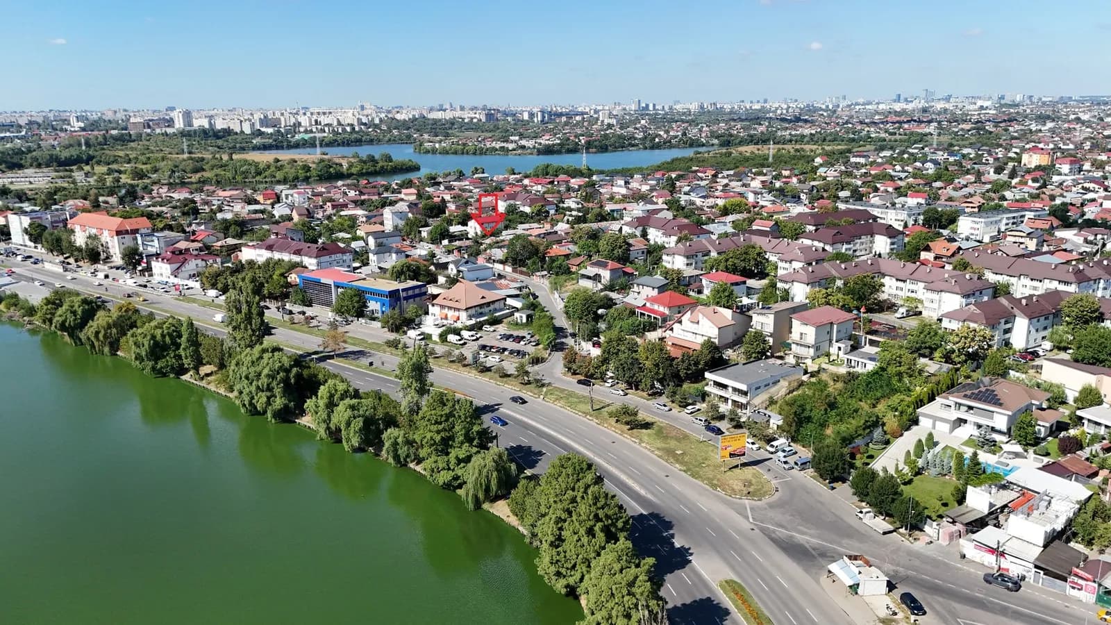 Teren pe malul râului, casele din vecinătate
