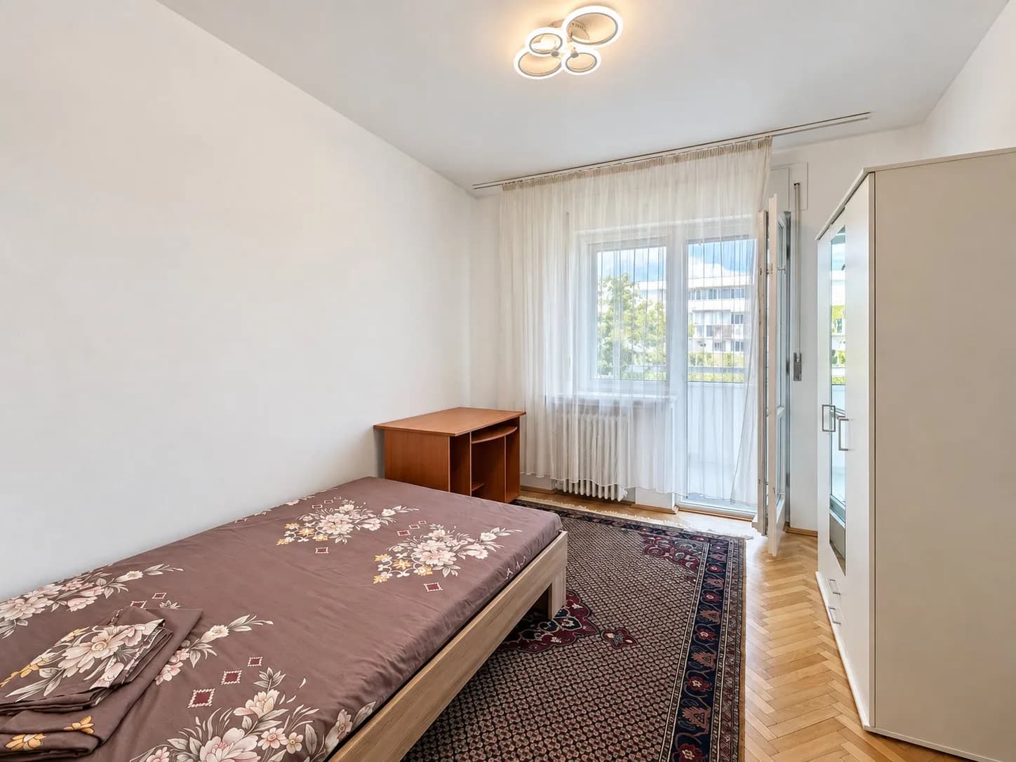 Dormitor cu pat, mobilă lemn, acces balcon