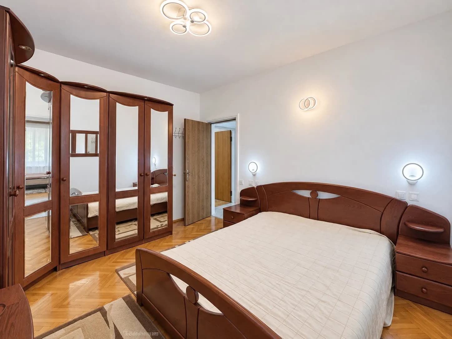 Dormitor matrimonial cu mobilă lemn și parchet