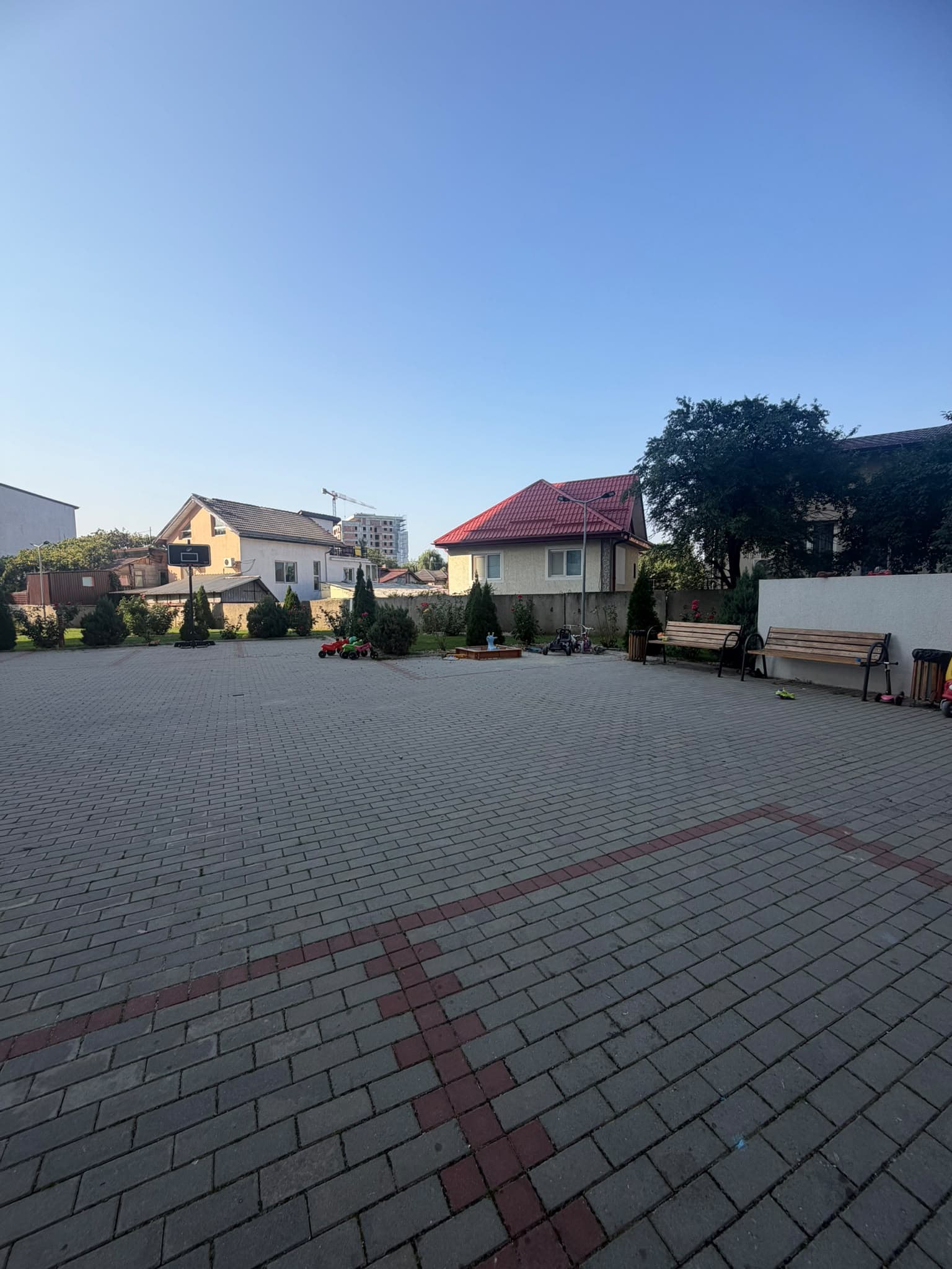Curte comună cu pavaj și case din jur