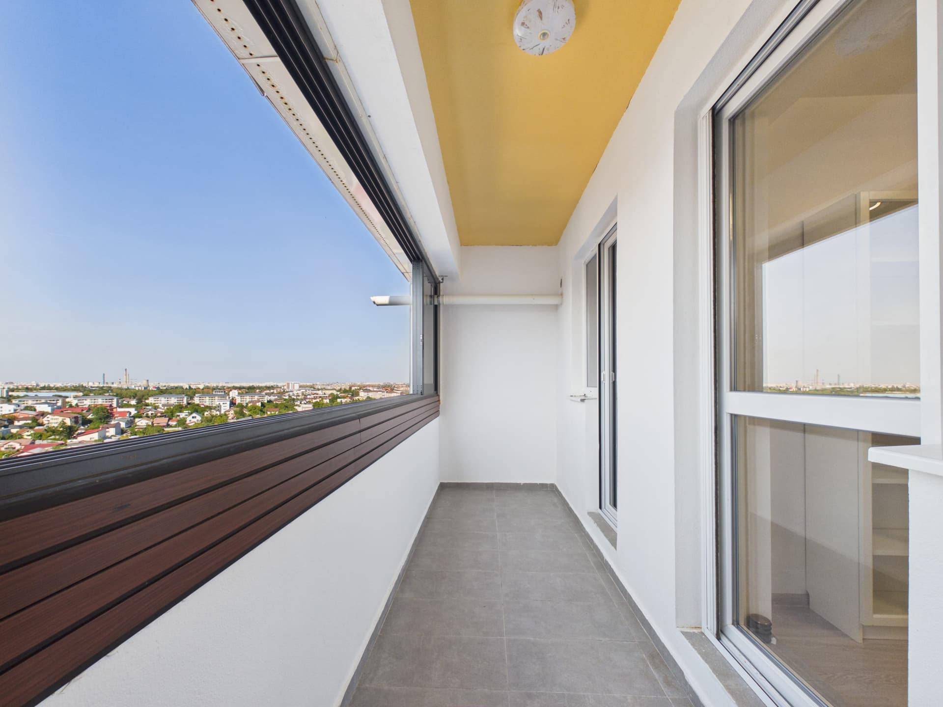 Balcon cu vedere către oraș și mobilier de lemn