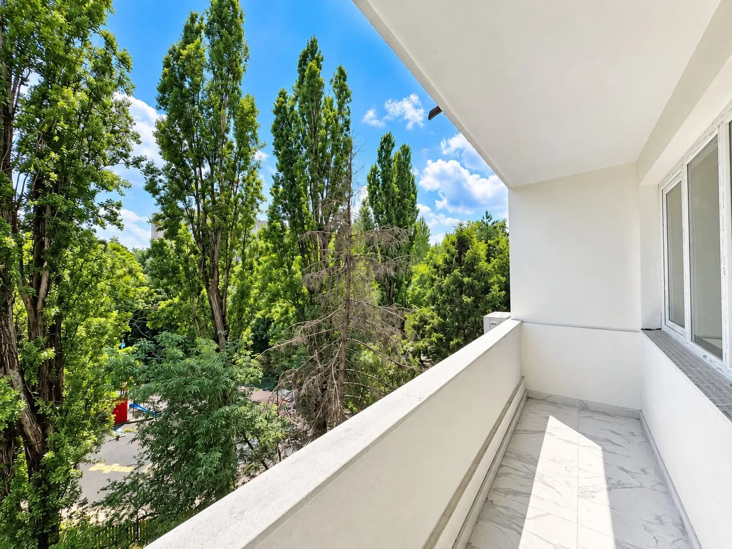 Balcon cu vedere spre copaci și cărări