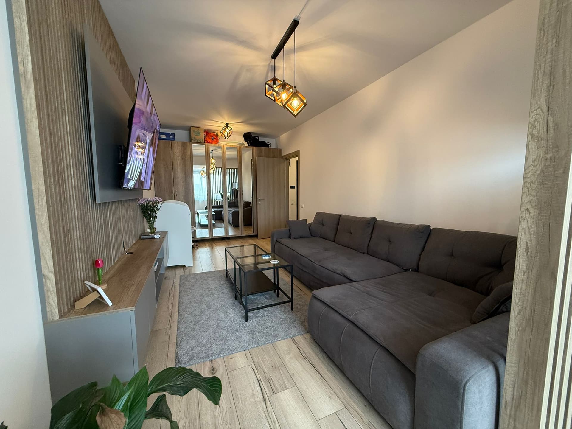 Living din alt unghi, sofa gri, mobilă TV, uși glisante
