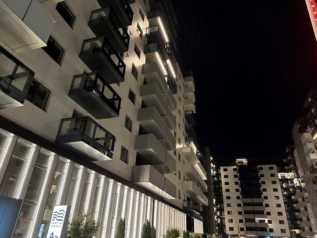 Fațada blocului rezidențial noaptea, iluminată