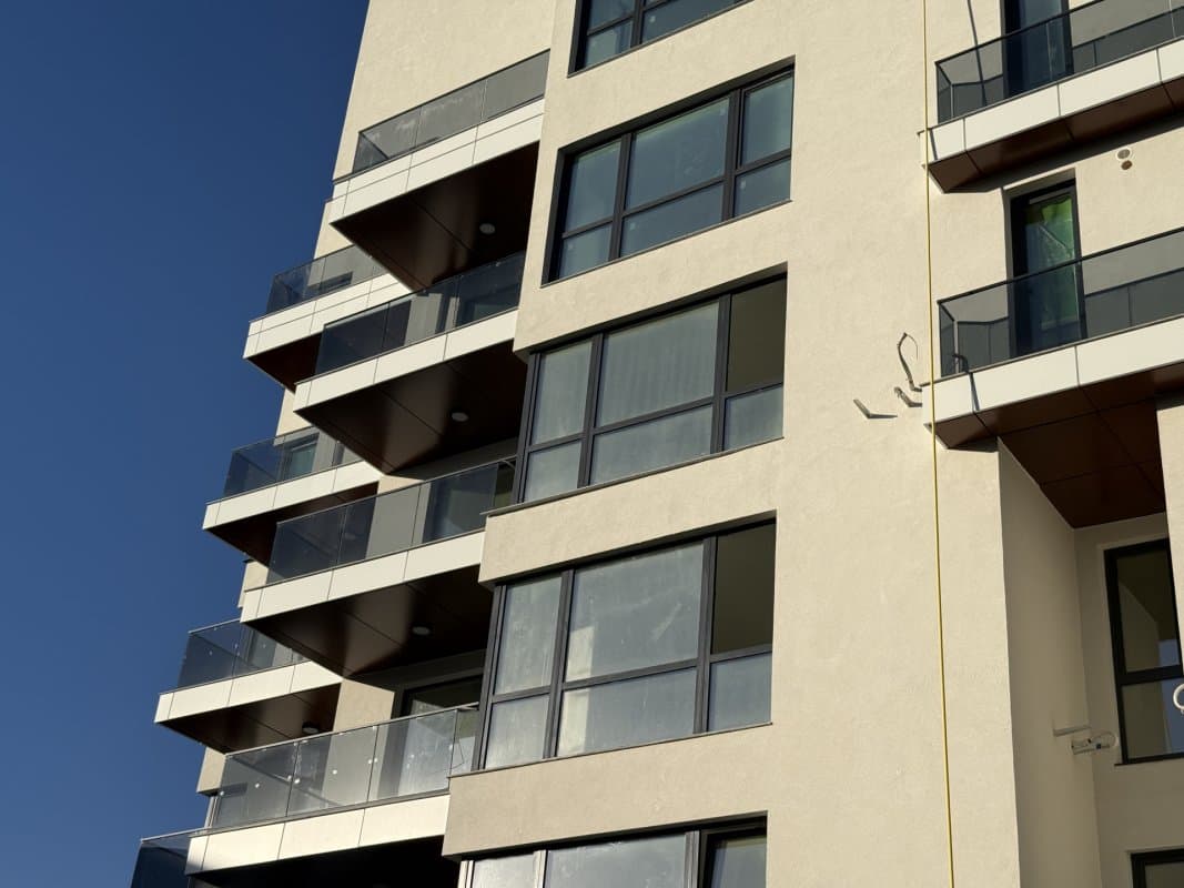 Fațada blocului cu balcoane și ferestrele apartamentelor