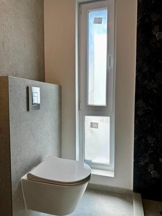 Toaletă cu wc și fereastră îngustă