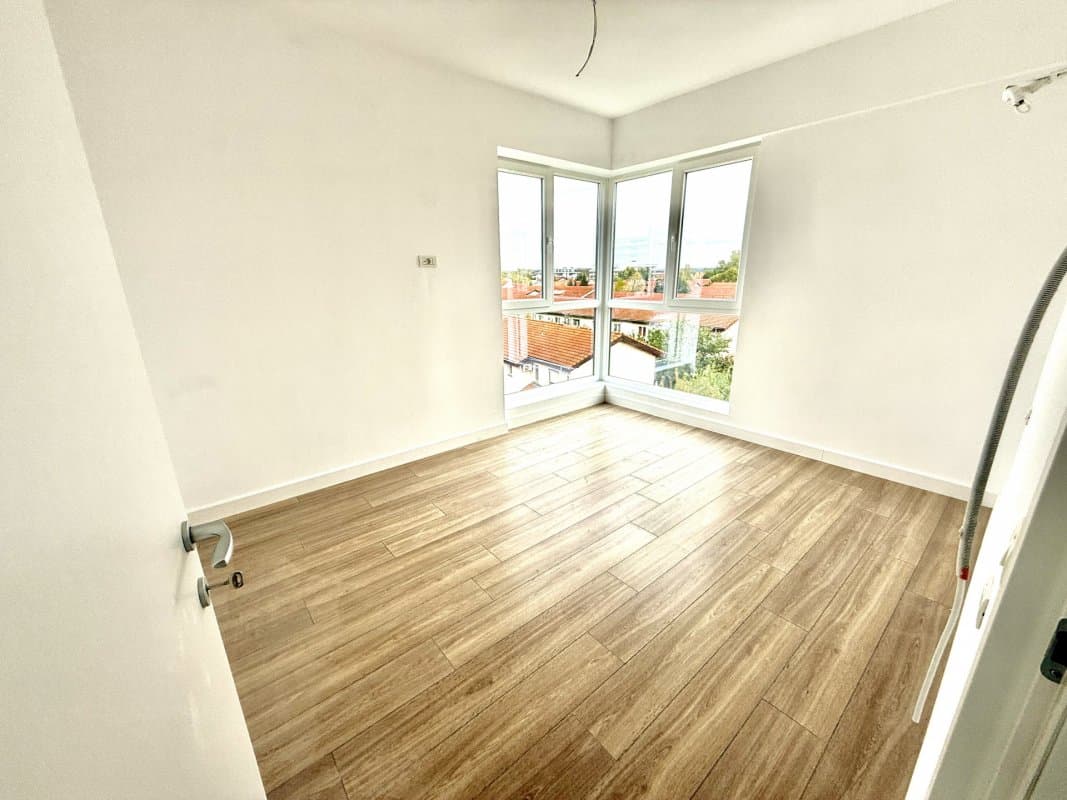 Dormitor cu parchet și ușă către balcon