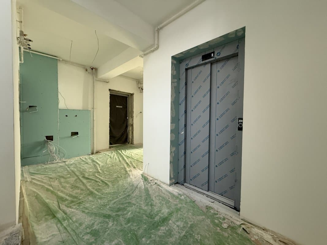Hol de intrare cu ușă de ascensor și ușă de apartament