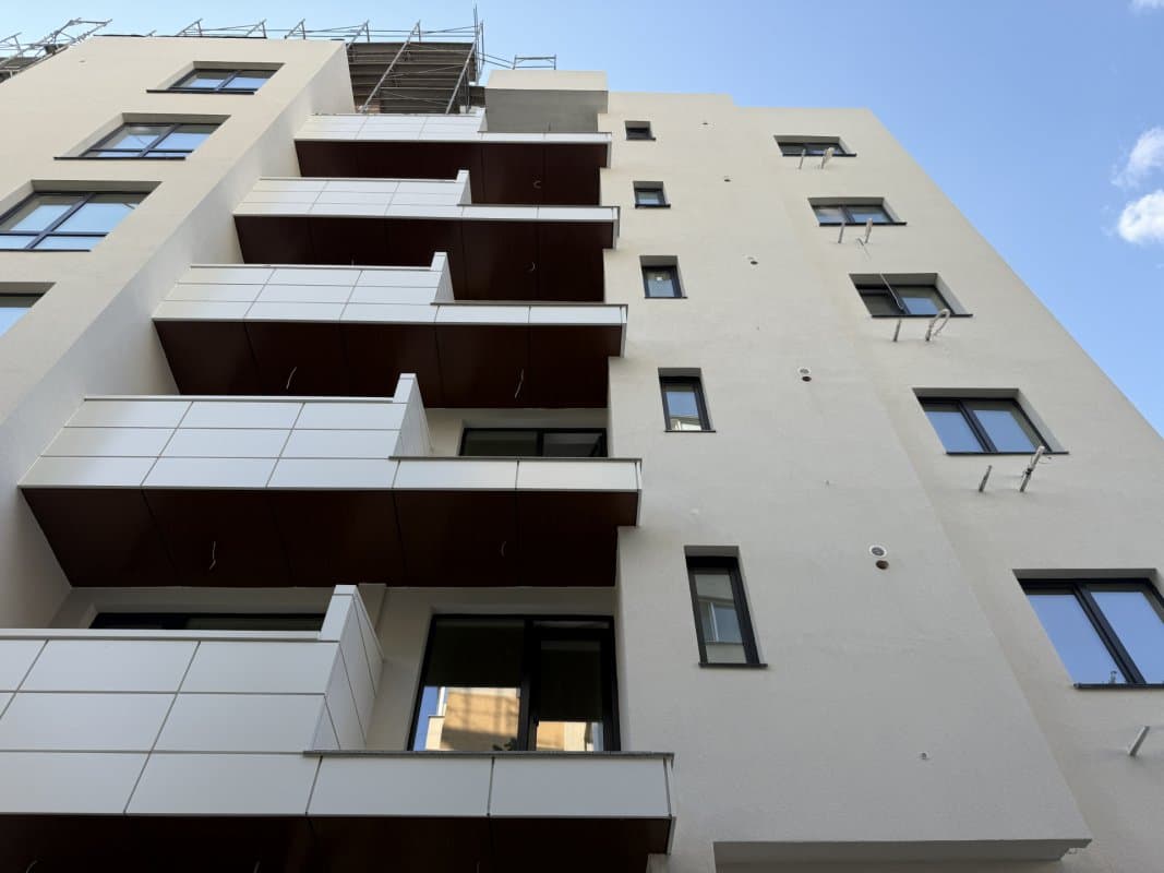 Fațada blocului cu balcoane și ferestrele apartamentelor