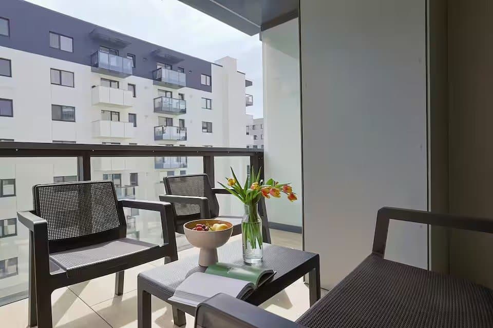 Balcon cu scaune și masă, vedere la blocuri vecine