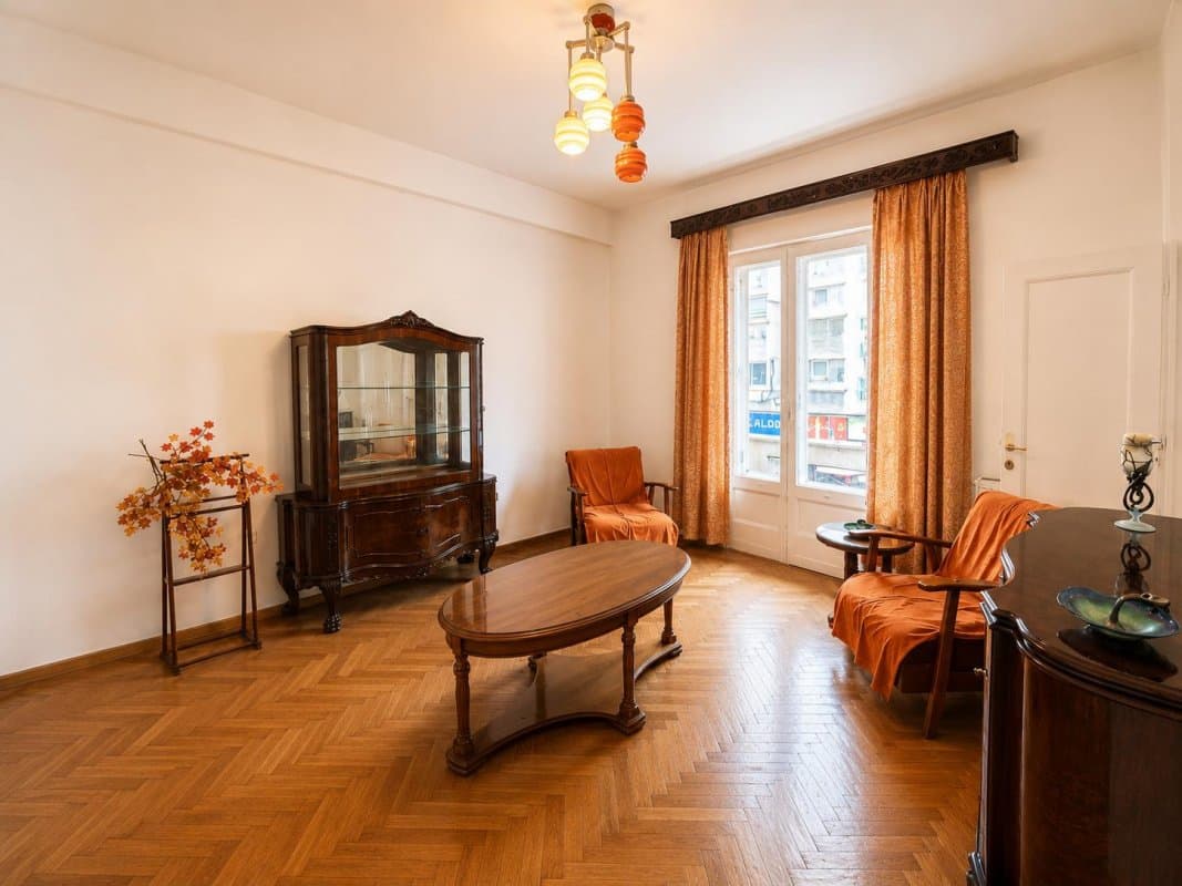 Living cu mobilă lemn și ușă către balcon