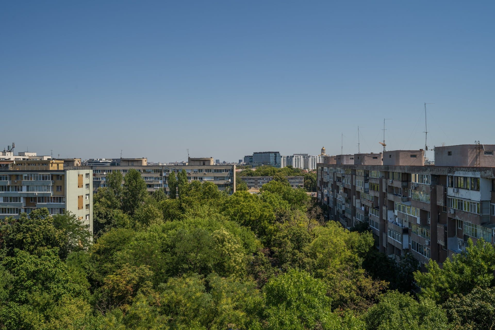 Panoramă urbană din balcon, blocuri și verdeață