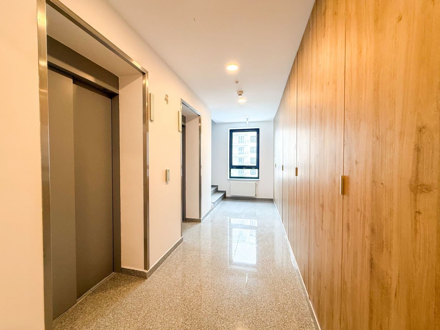 Coridor interior cu panou din lemn și ușă lift