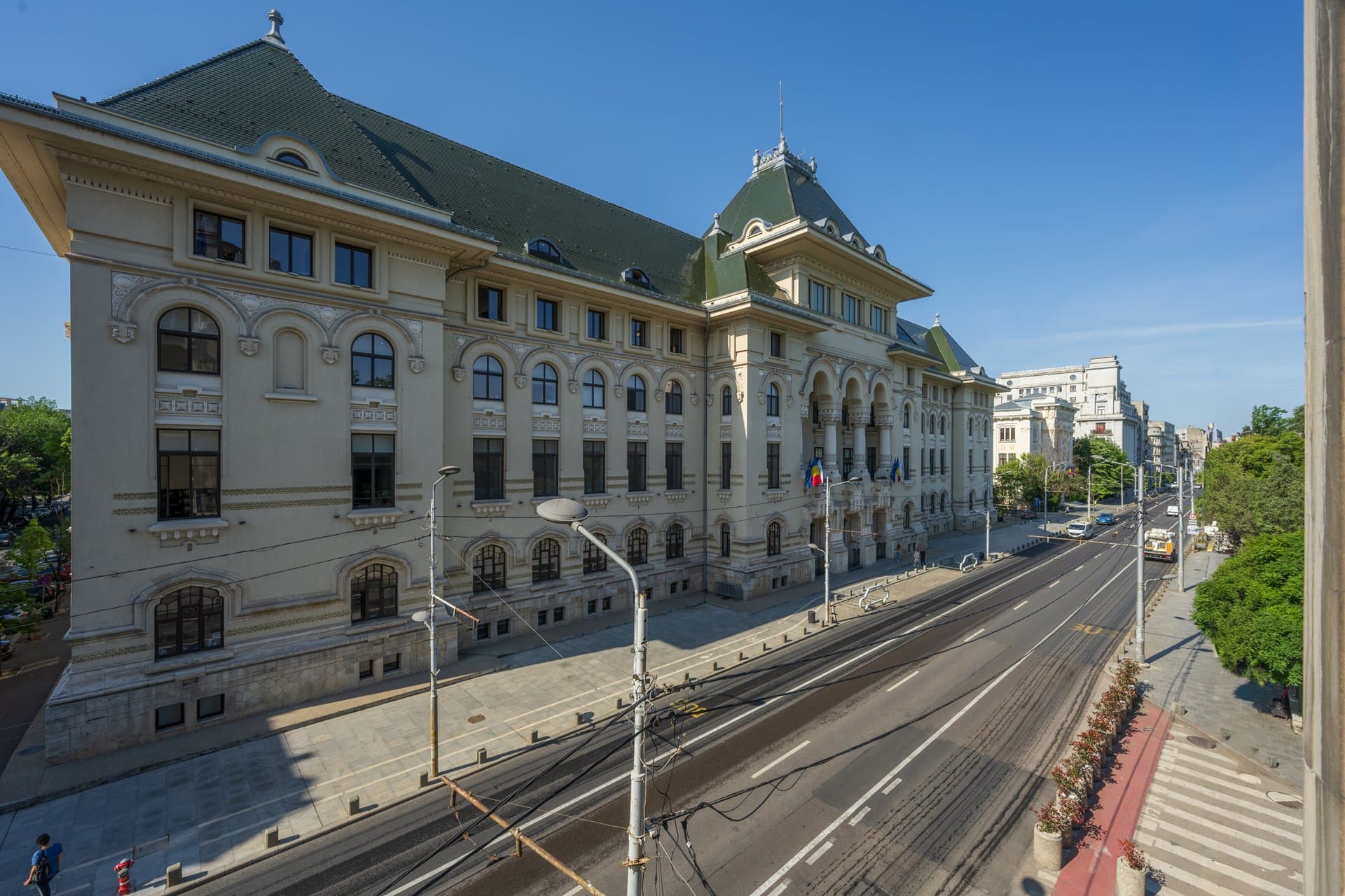 Fațada clădirii din unghiul opus, tramvai pe stradă