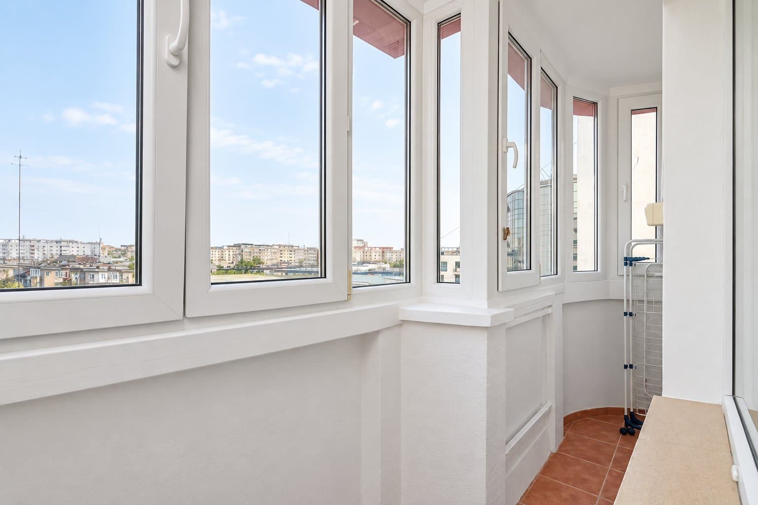 Balcon cu geamuri și vedere către cartierul rezidențial