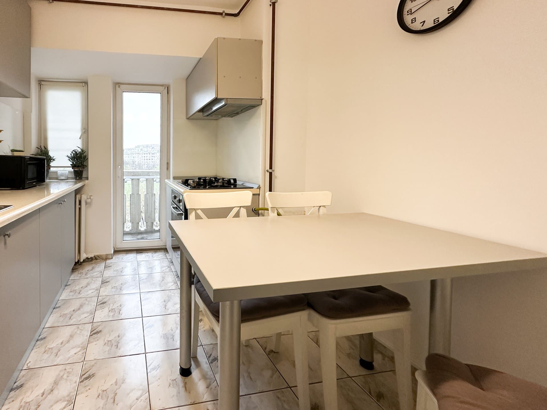 Bucătărie, masă pentru dining, vedere către ușa balconului