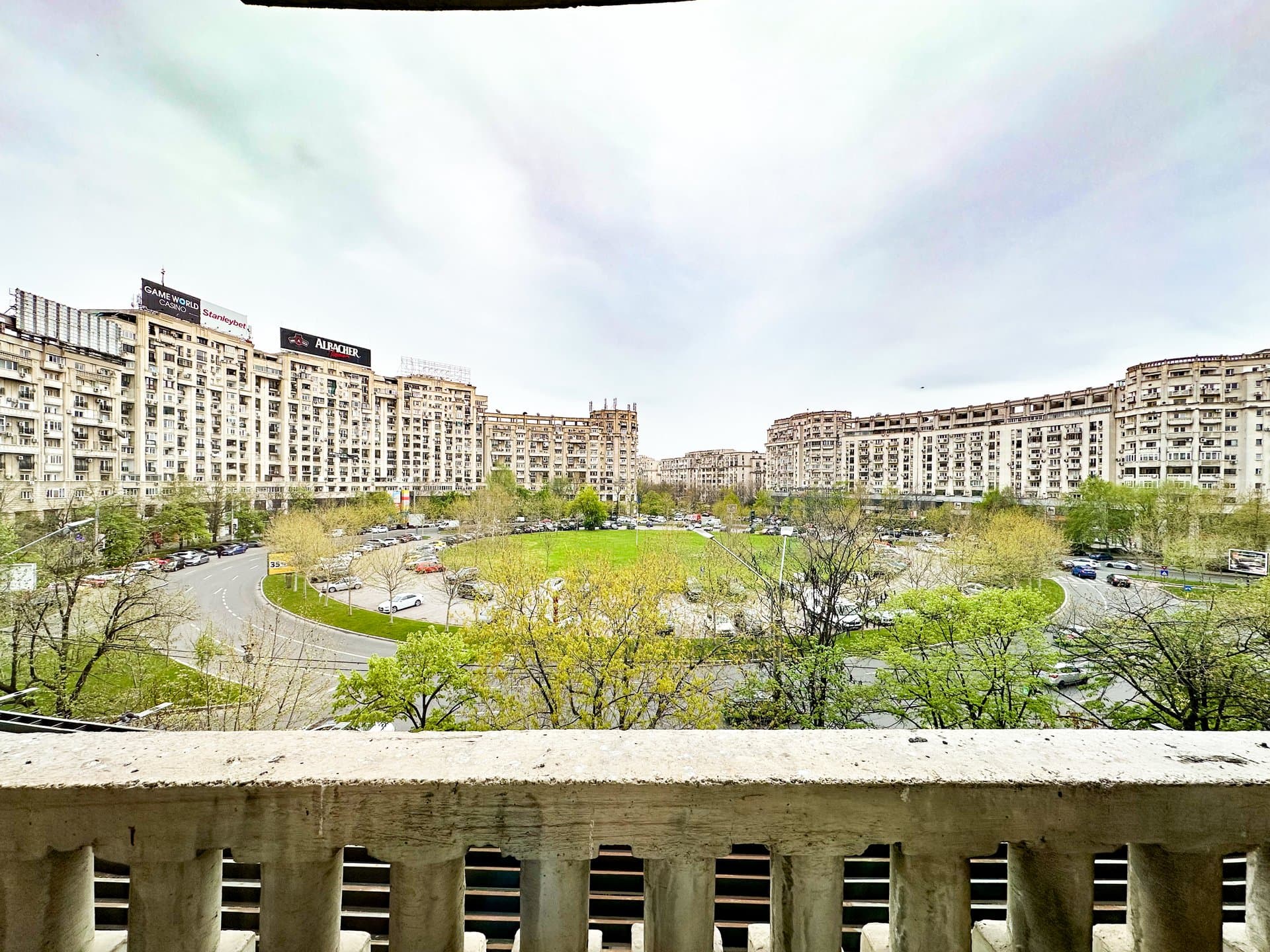 Vedere din balcon asupra parcului și blocurilor